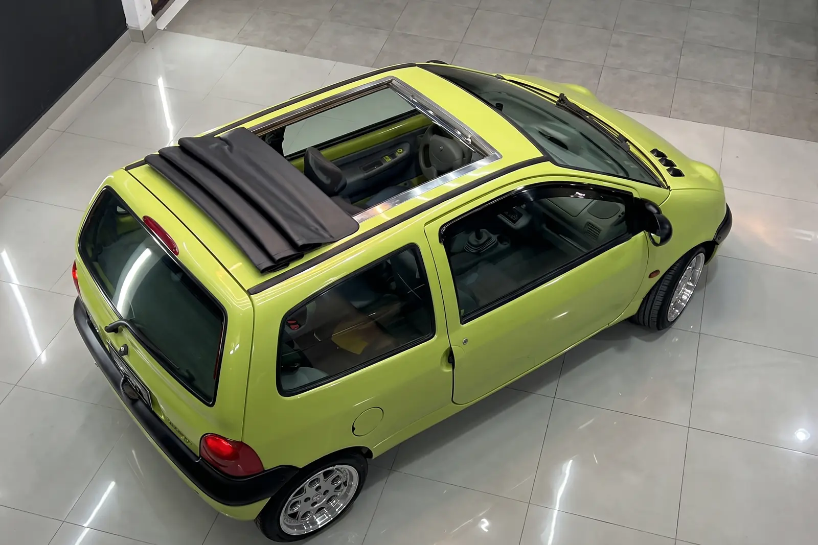 Teto solar de lona instalado em Renault Twingo, visto de cima com a lona recolhida sobre a traseira